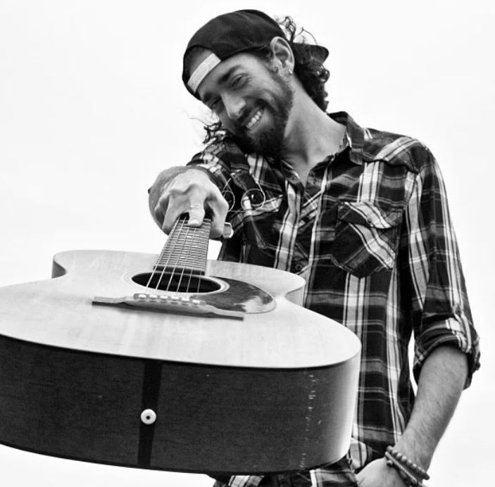 Musician Brandon Eardley holding a guitar
